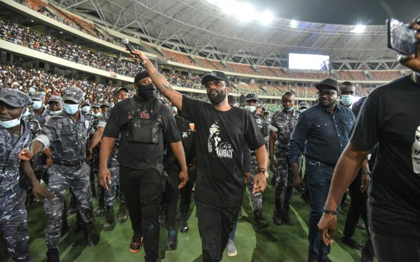 Fally Ipupa escorté par des policiers lors d'un concert au stade olympique d'Anyama à Abidjan le 17 mars 2021 afp.com - SIA KAMBOU