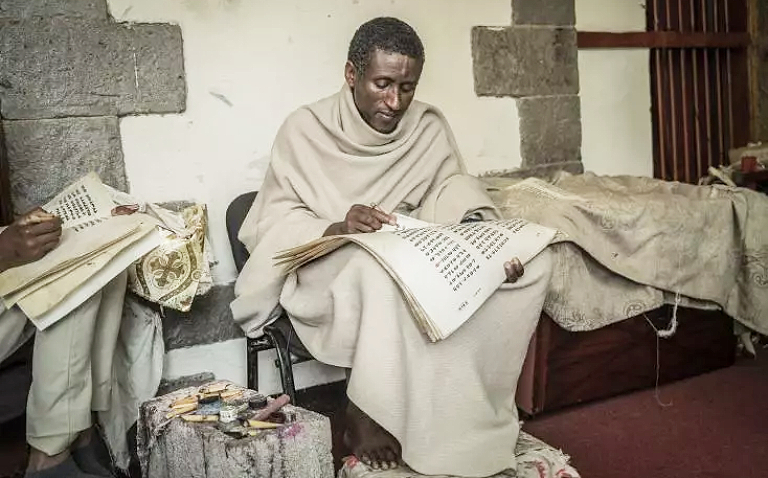 Zelalem Mola, prêtre orthodoxe éthiopien copie un livre religieux sur un parchemin, à l'institut Hamere Berhan d'Addis Abeba, en Ethiopie, le 17 mai 2023 AFP Amanuel Sileshi